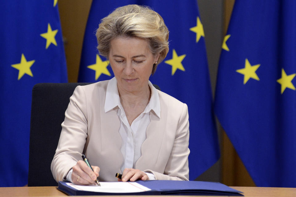 European Commission President Ursula von der Leyen signs the EU-UK Trade and Cooperation Agreement at the European Council headquarters in Brussels, Wednesday, Dec. 30, 2020. European Union's top officials have formally signed the post-Brexit trade deal sealed with the United Kingdom. European Commission president Ursula von der Leyen and European Council president Charles Michel put pen to paper on Wednesday morning during a brief ceremony in Brussels (Johanna Geron, Pool Photo via AP)