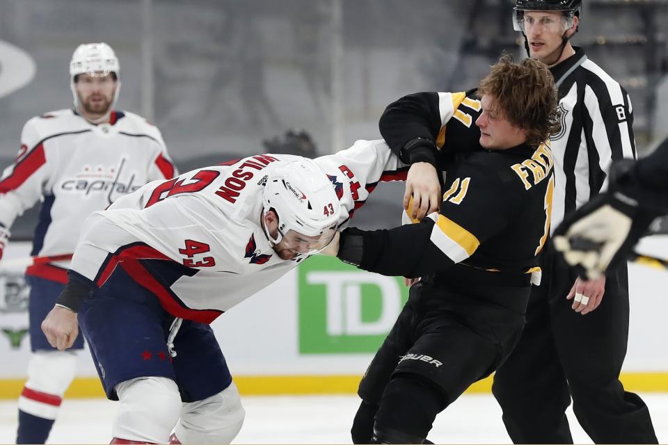 FILE - Boston Bruins' Trent Frederic (11) and Washington Capitals' Tom Wilson (43) fight during the third period of an NHL hockey game in Boston, in this Friday, March 5, 2021, file photo. The Boston Bruins and Washington Capitals already have bad blood built up going into their first-round playoff series that starts Saturday night. Game 1 will be Boston defenseman Brandon Carlo's first time on the ice against Tom Wilson since the Washington forward concussed him with a hit in March that drew a seven-game suspension. (AP Photo/Michael Dwyer, File)