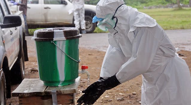 A health worker washes with disinfectant after dealing with people suspected of having the Ebola virus in the city of Monrovia, Liberia. Photo: AP