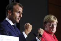 French President Emmanuel Macron and German Chancellor Angela Merkel attend a press conference on the situation in Sahel during the G7 summit in Biarritz, southwestern France, Sunday Aug. 25 2019. A top Iranian official paid an unannounced visit Sunday to the G-7 summit and headed straight to the building where leaders of the world's major democracies have been debating how to handle the country's nuclear ambitions. (Ian Langsdon, Pool via AP)