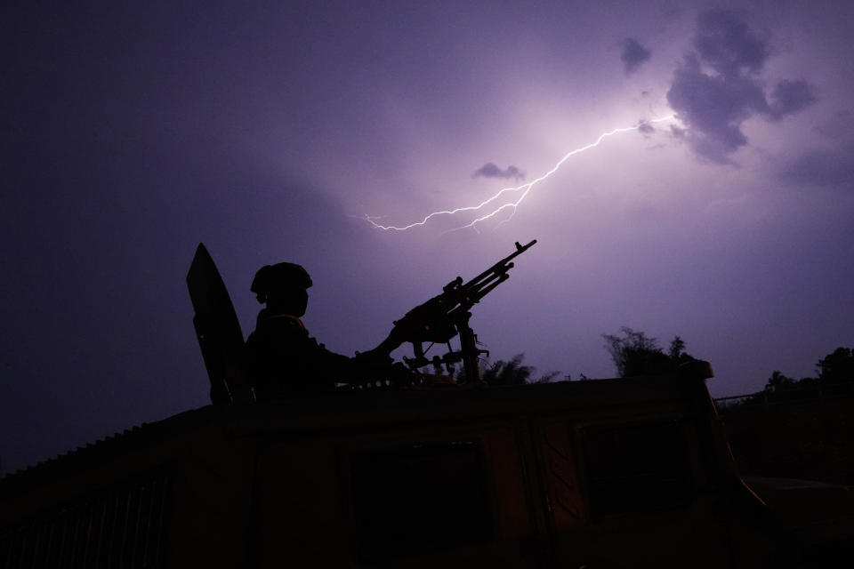 Lightning illuminates the sky behind the gunner on a Thai military armored vehicle, as he keeps watch along the Moei river, under the 2nd Thai-Myanmar Friendship Bridge in Mae Sot in Thailand's Tak province on Friday, April 12, 2024. Thailand's foreign minister on Friday said he has urged Myanmar's military authorities not to violently respond to its army's loss of an important border trading town to its opponents, and that so far it seems to be exercising restraint. (AP Photo/Sakchai Lalit)