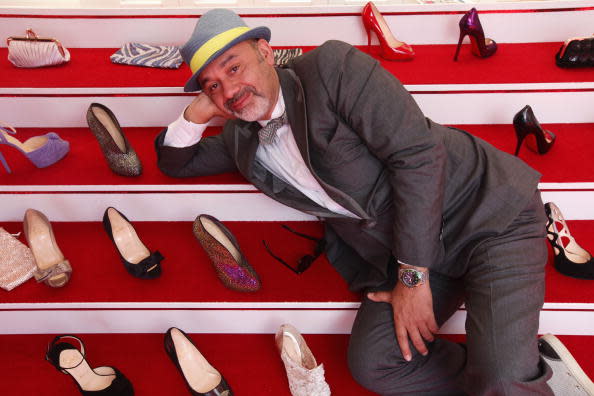 Shoe designer Christian Louboutin poses with his coveted red-soled creations.