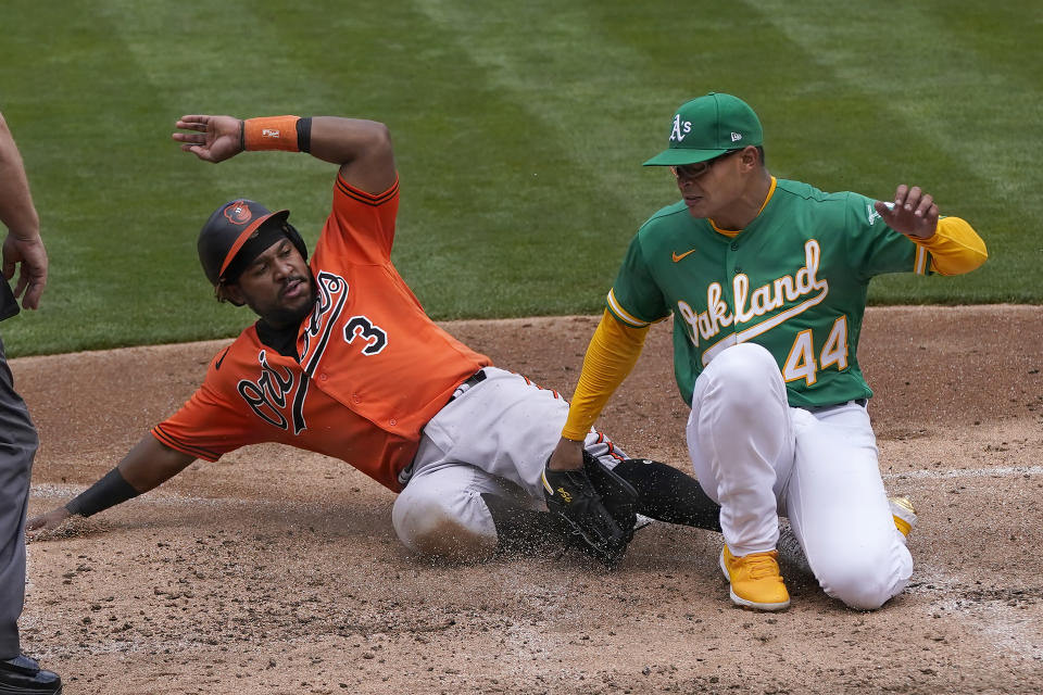 Baltimore Orioles' Maikel Franco (3) slides home to score against Oakland Athletics pitcher Jesus Luzardo (44) during the third inning of a baseball game in Oakland, Calif., Saturday, May 1, 2021. (AP Photo/Jeff Chiu)