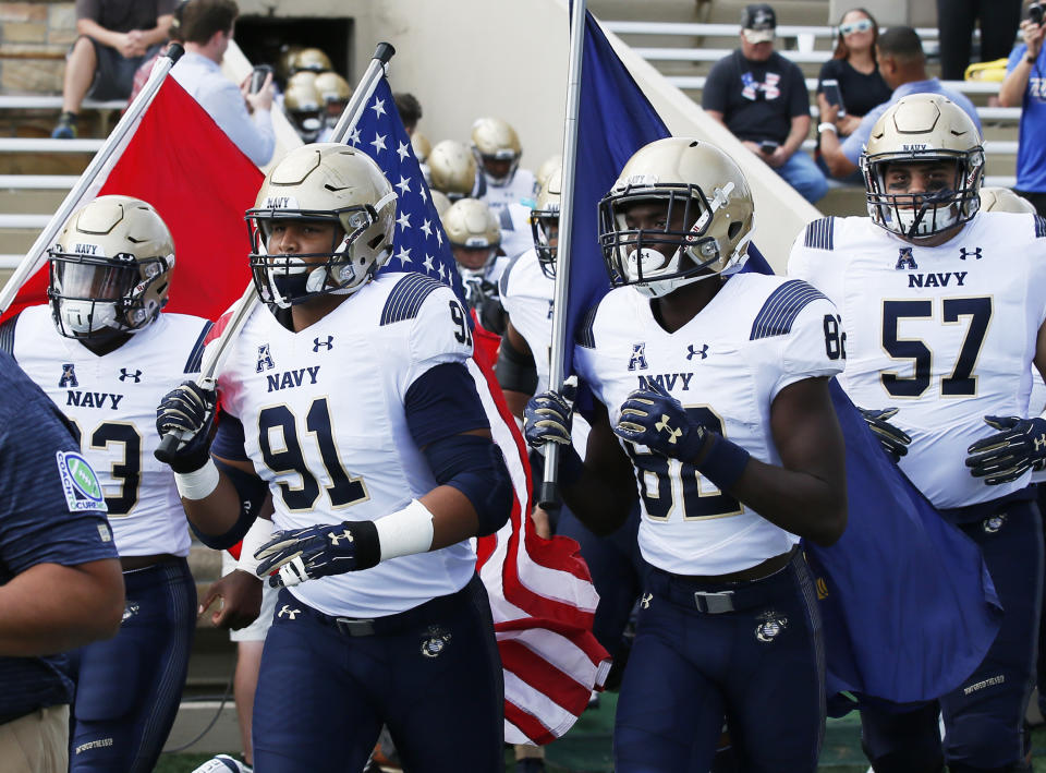 Navy defensive end Tyler Sayles (91) leads his team onto the field carrying the flag before an NCAA college football game against Tulsa in Tulsa, Okla., Saturday, Sept. 30, 2017. (AP Photo/Sue Ogrocki)