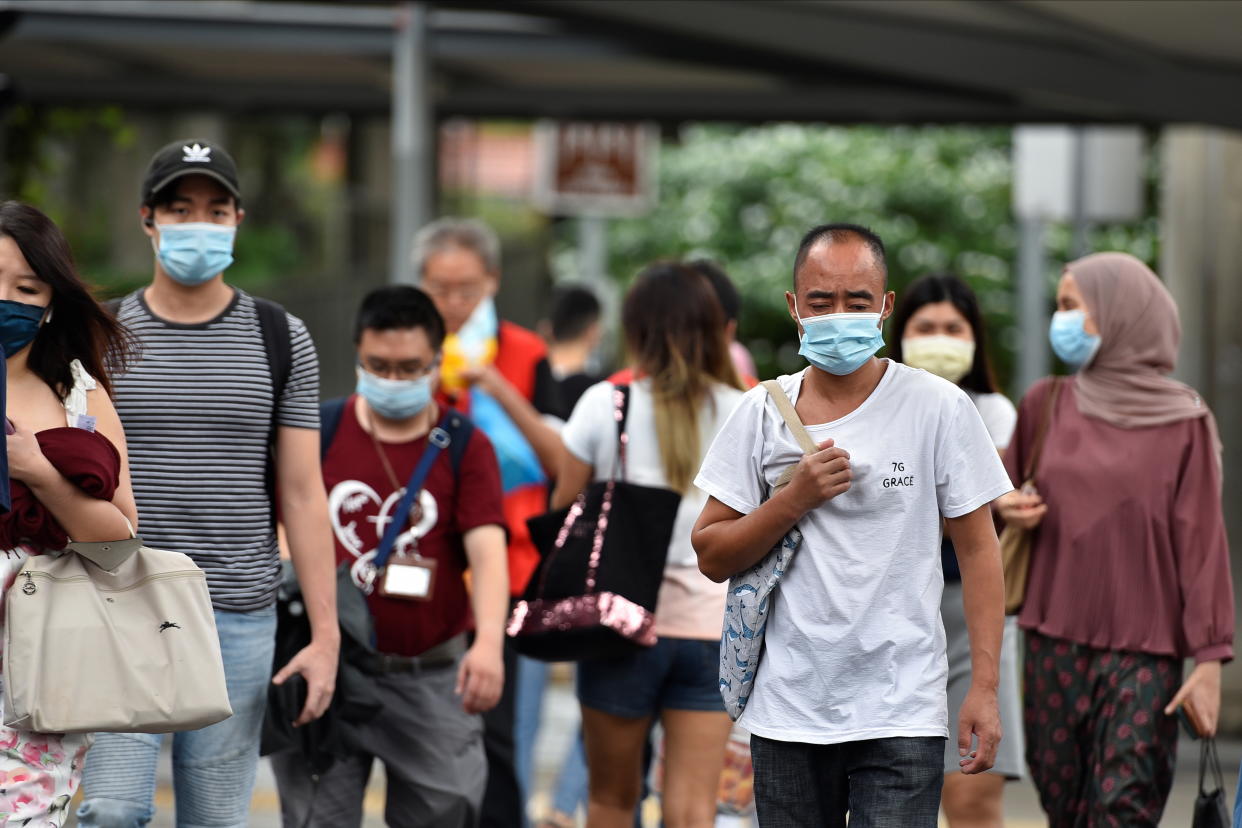 People wearing face masks cross a road amid the coronavirus disease (COVID-19) outbreak in Singapore May 14, 2021. REUTERS/Caroline Chia