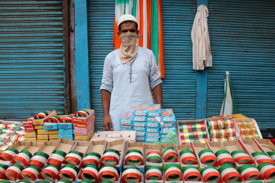 A vendor with face mask as a precautionary measure against Covid-19, sells tri-coloured bangles ahead of Independence Day celebrations at Lal Kuan on August 12, 2020 in Delhi, India. (Photo by Mayank Makhija/NurPhoto via Getty Images)