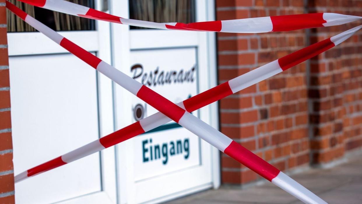 Mit rot-weißem Absperrband ist der Zugang zu einem Restaurant in Boizenburg abgesperrt. Außenbereiche von Lokalen sollen dem Entwurf zufolge erst öffnen, wenn die Inzidenz 14 Tage stabil unter 35 bleibt.