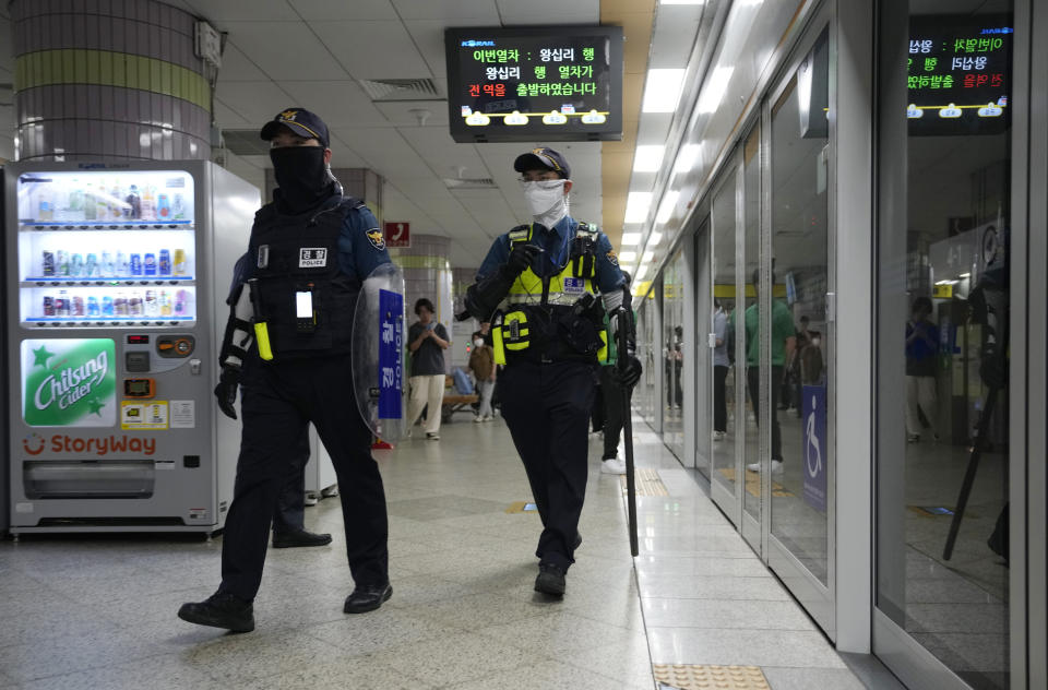 Police officers patrol at Ori subway station following Thursday's attack in Seongnam, South Korea, Friday, Aug. 4, 2023. South Korean police detained a man suspected of stabbing a high school teacher with a knife Friday in the city of Daejeon. The stabbing follows a separate, apparently random attack on Thursday in which 14 people were wounded near a busy subway station in Seongnam. (AP Photo/Ahn Young-joon)