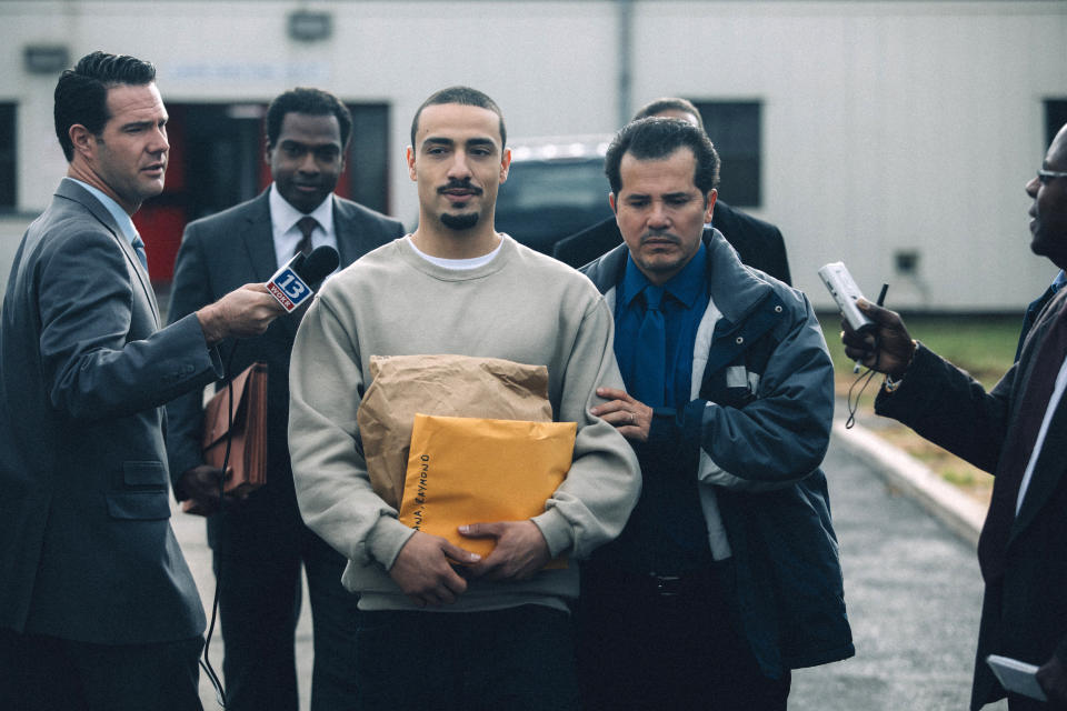 This image released by Netflix shows Freddy Miyares as Adult Raymond Santana Jr. and John Leguizamo as Raymond Santana Sr., right, in a scene from "When They See Us." Leguizamo returns to the Emmy Awards as a nominee for his performance in the Netflix docudrama. He is currently in Los Angeles at the Ahmanson Theatre for a six-week run of his Tony-nominated one-man show “Latin History for Morons,” in which he offers an eye-opening lesson about the participation of Latin Americans throughout U.S. history. (Atsushi Nishijima/Netflix via AP)