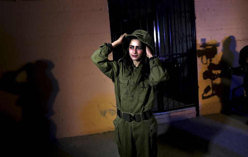 In this Wednesday, Jan. 29, 2014 photo, Fayka al-Najar, who plays an Israeli female soldier, adjusts her hat on the set of a movie being made in Gaza called, '' Losing Shalit,'' adjusts her hat during filming in Gaza City. "Losing Schalit," currently being filmed in the blockaded territory, is the first of a planned three-part series about the 2006 capture of Israeli soldier Gilad Schalit by gunmen allied with the Islamic militant Hamas movement. Parts two and three will depict Schalit's time in captivity and his 2011 swap for hundreds of Palestinian prisoners held by Israel. (AP Photo/Hatem Moussa)