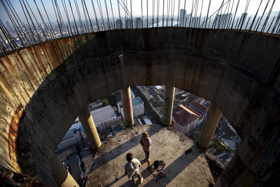 Visitors stand inside an abandoned building in Bangkok. The abandoned building, known as Sathorn Unique, dubbed the 'ghost tower' was destined to become one of Bangkok's most luxurious residential addresses but construction was never completed as the Thai economy was hit during the 1997 Asian Financial Crisis. Now, many travellers visit and explore the 49-story skyscraper. (REUTERS/Athit Perawongmetha)