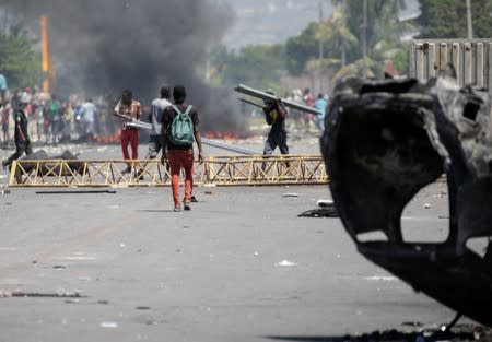 Protesters walk away after looting a police station during a demonstration demanding the resignation of Haitian President Jovenel Moise in Port-au-Prince