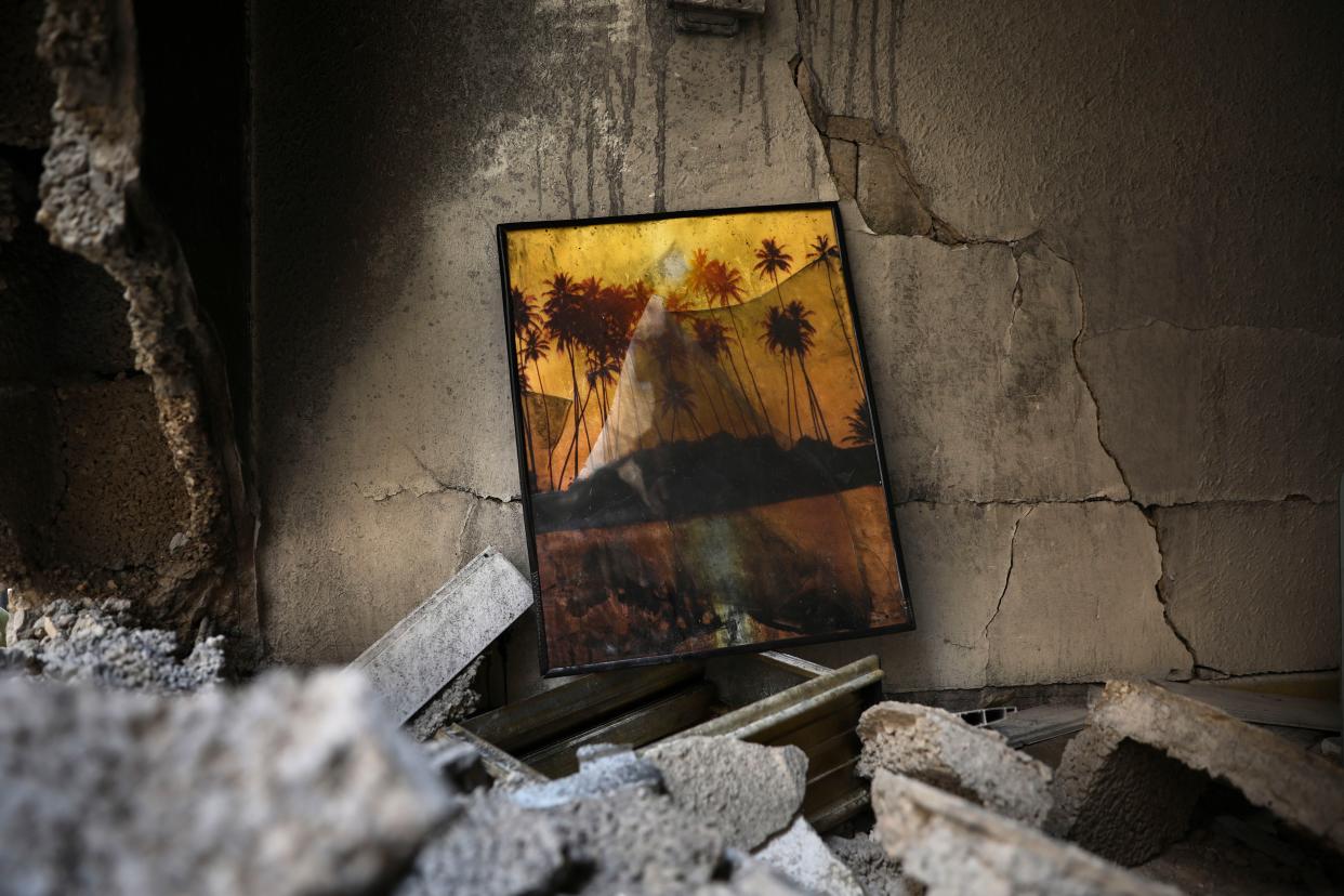 A damaged picture frame lies amid the rubble of a destroyed apartment after being hit by a rocket fired from the Gaza Strip overnight in Petah Tikva, central Israel, Thursday, May 13, 2021.