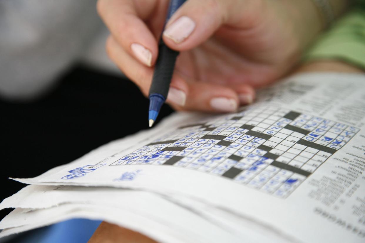 Working on a crossword puzzle.