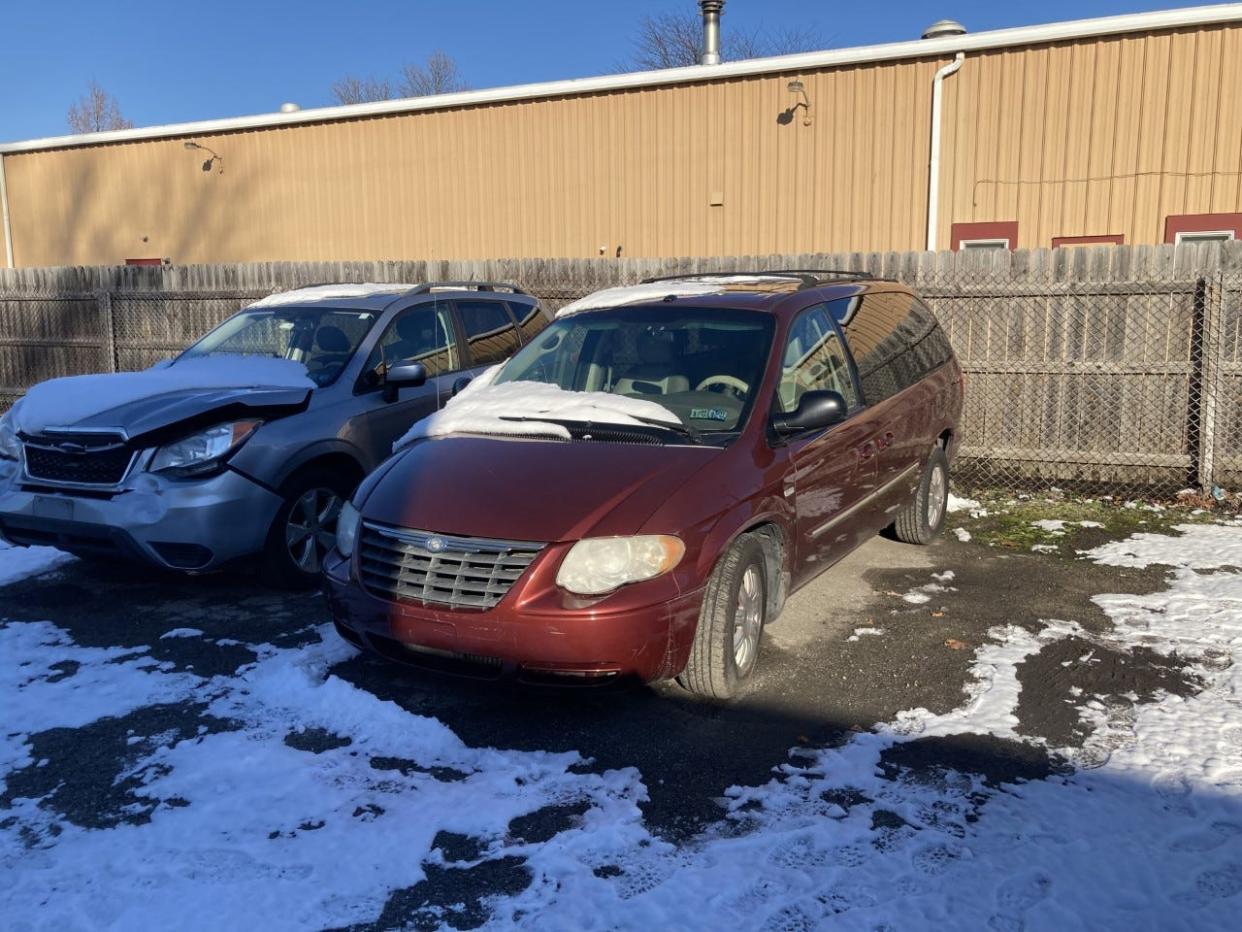 JD Mullane's '07 Town & Country minivan awaiting disposal in the yard of an auto body shop.