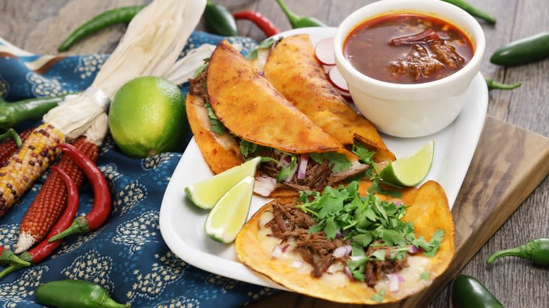 Birria tacos with chili and limes