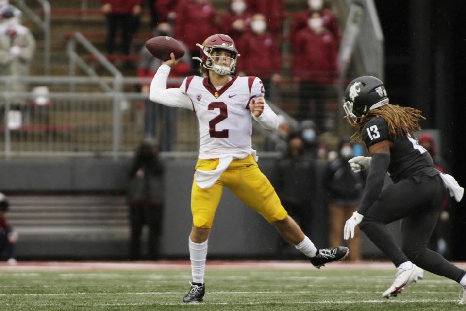 USC quarterback Jaxson Dart throws a pass while pressured by Washington State linebacker Jahad Woods.