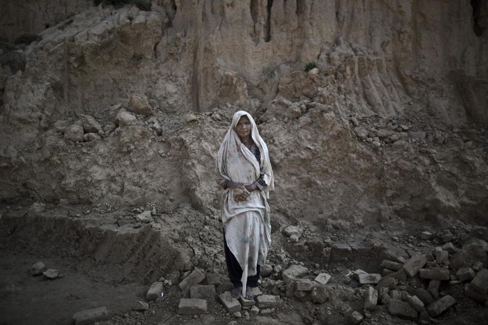 In this Sunday, March 2, 2014, photo, Amna Bhatti, 60, a Pakistani brick factory worker, poses for a picture at the site of her work in Mandra, near Rawalpindi, Pakistan. Amna is in debt to her employer the amount of 150,000 rupees (approximately $1,500). (AP Photo/Muhammed Muheisen)