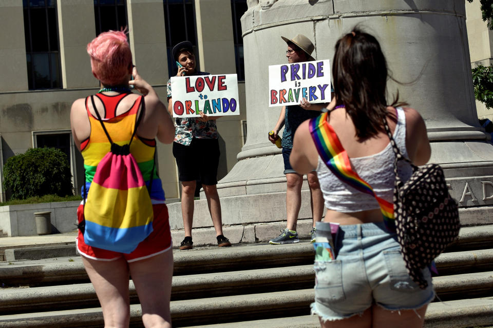 <p>Nick Wilson and Ciaran Lithgow, both of Washington, DC, hold signs of condolence for victims of the attack on a gay nightclub in Orlando, Florida early this morning in Washington June 12, 2016. (REUTERS/James Lawler Duggan) </p>