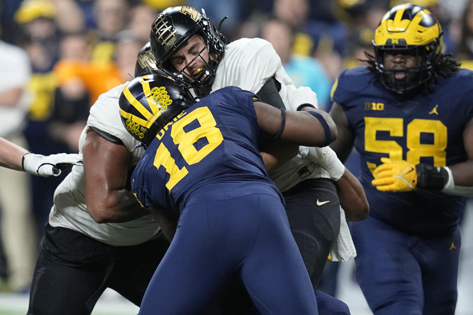 Purdue quarterback Aidan O'Connell is sacked by Michigan linebacker Eyabi Okie (18) during the second half of the Big Ten championship NCAA college football game, Saturday, Dec. 3, 2022, in Indianapolis. (AP Photo/Darron Cummings)