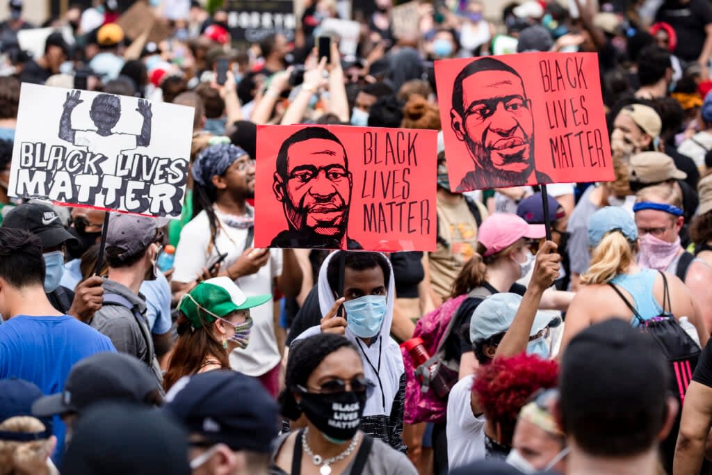 Protesters walk along the recently renamed Black Lives Matter Plaza with signs near the White House during George Floyd protests on June 6, 2020 in Washington, D.C. (Photo by Samuel Corum/Getty Images)