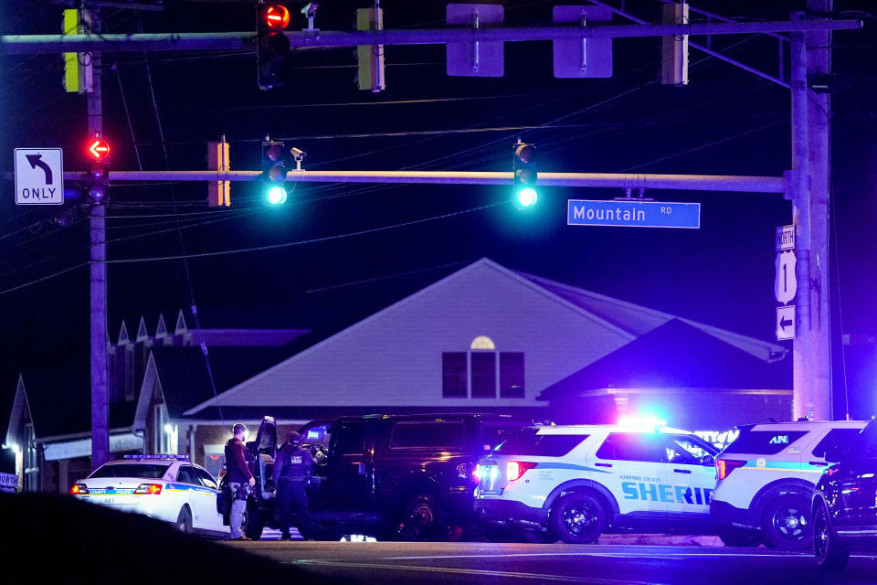 Police officers deploy at a checkpoint on Mountain Road and Belair Road where a suspected gunman is believed to be at large, Thursday, Feb. 9, 2023, in Fallston, Md. A second police officer in Maryland has been injured in gunfire as Baltimore County police continue searching for a suspect amid a large manhunt that began after a different officer was shot Wednesday. (AP Photo/Julio Cortez)