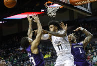 Oregon guard Rivaldo Soares (11) makes a pass against Washington guard Terrell Brown Jr. (23) in the first half of an NCAA college basketball game in Eugene, Ore., Sunday, Jan. 23, 2022. (AP Photo/Thomas Boyd)