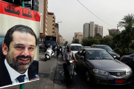 Cars pass next to a poster depicting Saad al-Hariri, who has resigned as Lebanon's prime minister, in Beirut, Lebanon,, Lebanon, November 13, 2017. REUTERS/Mohamed Azakir
