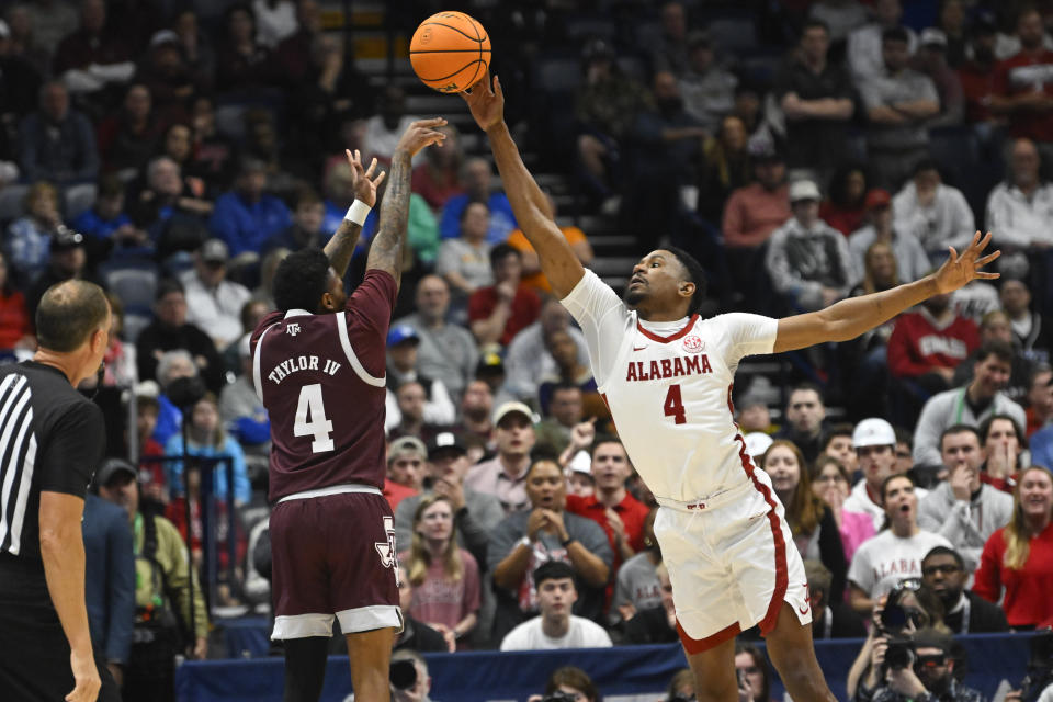 Texas A&M guard Wade Taylor IV shoots as Alabama forward Noah Gurley, right, defends during the first half of an NCAA college basketball game in the finals of the Southeastern Conference Tournament, Sunday, March 12, 2023, in Nashville, Tenn. (AP Photo/John Amis)