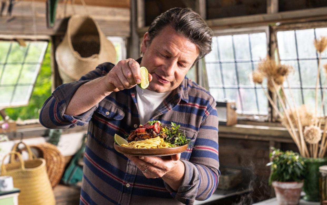 Oliver squeezes a lime over a pasta dish