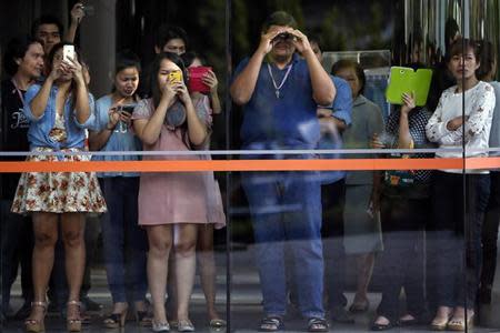 People look and take pictures from inside a business building owned by SC Asset Corp, as anti-government protesters gather outside, in Bangkok February 19, 2014. REUTERS/Damir Sagolj