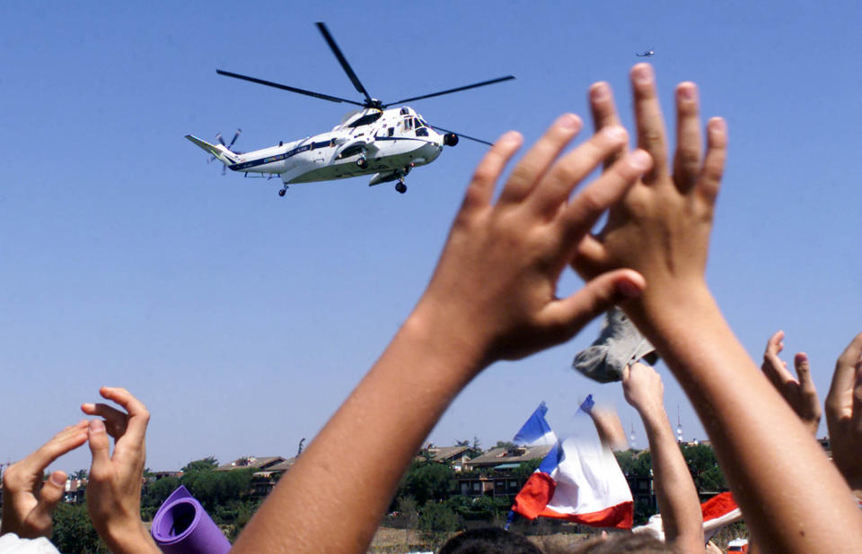 FILE - Youths wave goodbye to the helicopter carrying Pope John Paul II, as the Pontiff leaves the grounds of Tor Vergata after leading a Sunday Mass for some 2 million youths on Aug. 20, 2000. (AP Photo/Enric Marti, File)