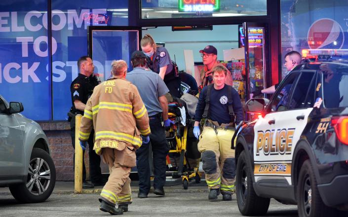 Paramedics work to save the victim of a shooting inside the Quick Stop at West 18th and Chestnut streets in Erie on May 16. The victim, Jalen Rieger-Williams, died from a gunshot wound to the chest.