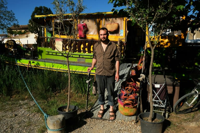 Gaston Degois poses in front of his grocery barge in Le Somail, on the Canal du Midi, near Narbonne in southern France