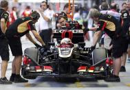 Lotus F1 Formula One driver Romain Grosjean of France removes his gloves as he sits in his car during the third practice session of the Singapore F1 Grand Prix at the Marina Bay street circuit in Singapore September 21, 2013. REUTERS/Pablo Sanchez (SINGAPORE - Tags: SPORT MOTORSPORT F1)