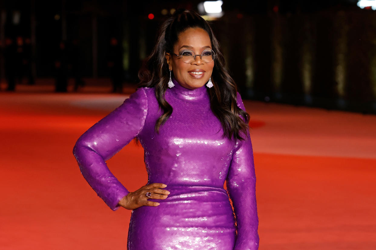  Oprah smiling at a red carpet event. 