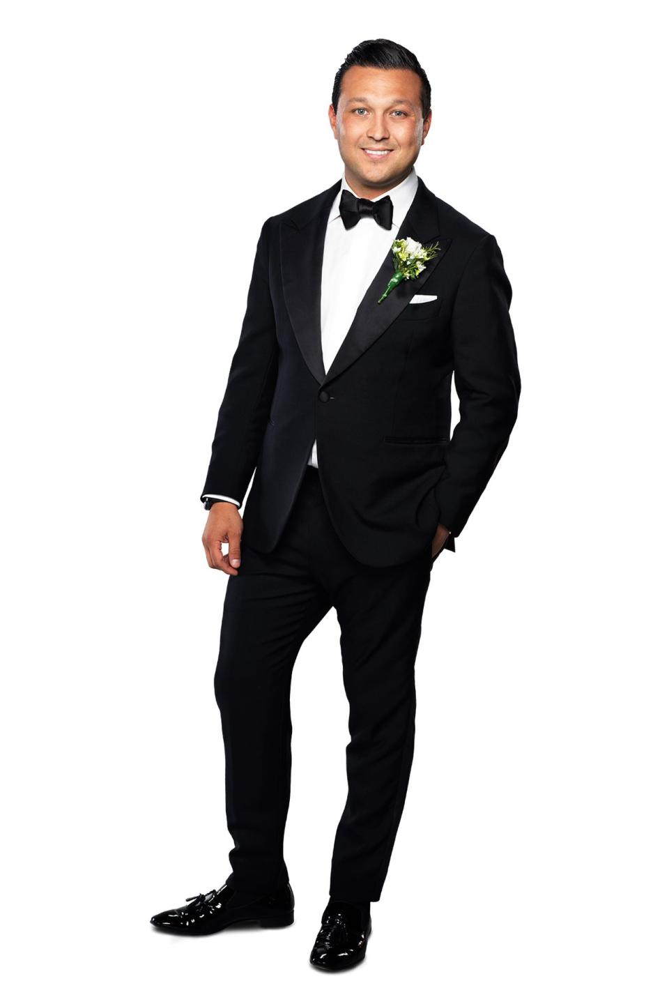 New groom Dion in his tuxedo on Married At First Sight 2022. He has short dark hair and wears a bow tie.