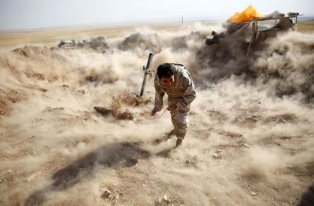 A Kurdish Peshmerga fighter launches mortar shells towards Zummar, controlled by Islamic State (IS), near Mosul September 15, 2014. REUTERS/Ahmed Jadallah