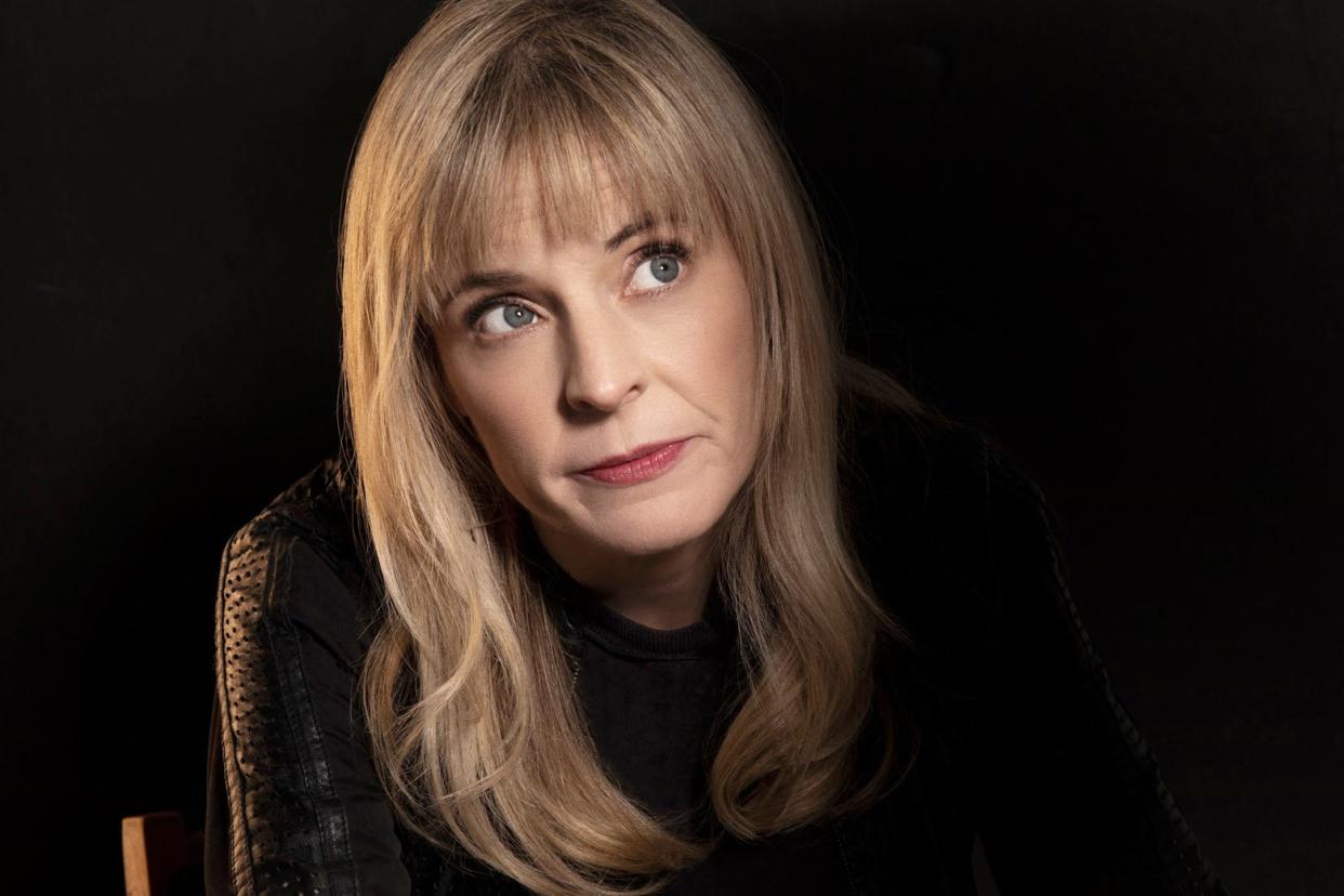 Maria Bamford wears a dark sweater and stares upward.