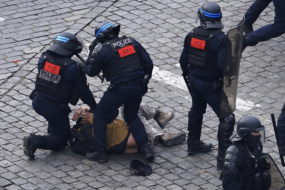 A protester is detained by riot police officers during a demonstration, Tuesday, March 7, 2023 in Paris. Hundreds of thousands of demonstrators across France took part Tuesday in a new round of protests and strikes against the government's plan to raise the retirement age to 64, in what unions hope will be their biggest show of force against the proposal. (AP Photo/Aurelien Morissard)