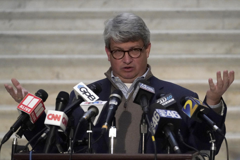 Gabriel Sterling with the Georgia secretary of state's office speaks into a dozen microphones at a podium in front of a white staircase.