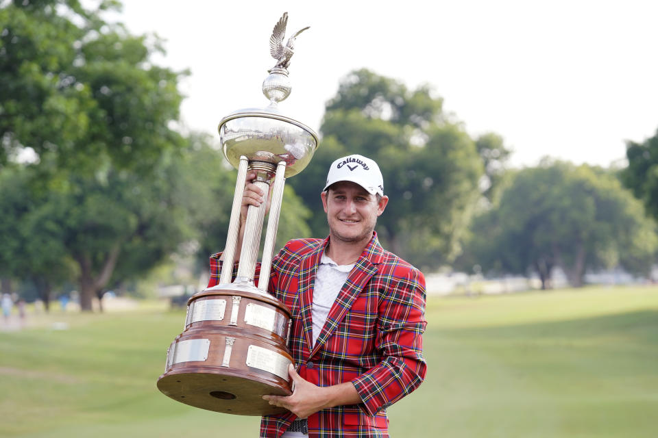 Emiliano Grillo, of Argentina, poses with the trophy after winning the Charles Schwab Challenge golf tournament at Colonial Country Club in Fort Worth, Texas, Sunday, May 28, 2023. (AP Photo/LM Otero)