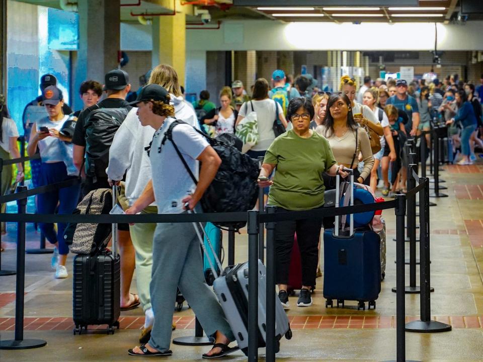 People stand in line at the Kahului Airport.