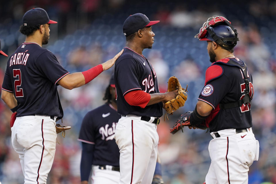 Washington Nationals shortstop Luis Garcia, left, waits with starting pitcher Josiah Gray and catcher Keibert Ruiz for Gray to be pulled during the sixth inning of the team's baseball game against the Miami Marlins at Nationals Park, Friday, July 1, 2022, in Washington. (AP Photo/Alex Brandon)