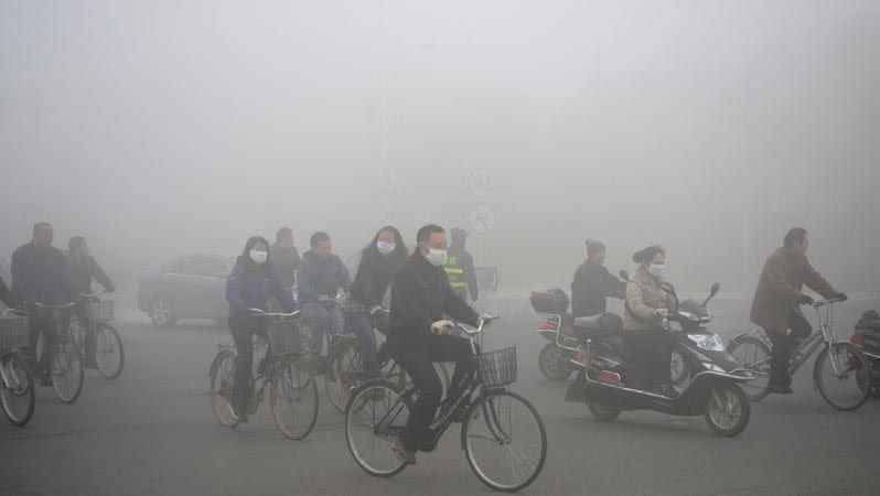 People ride along a street on a smoggy day in Daqing, Heilongjiang province. Photo: Reuters