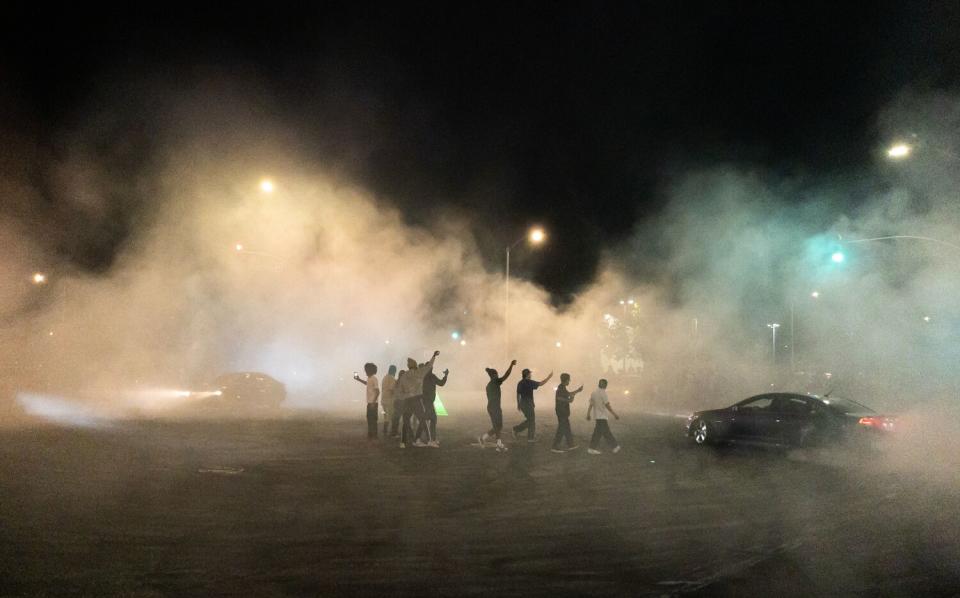 Cars drifts around spectators at Compton Boulevard and Atlantic Avenue in East Compton