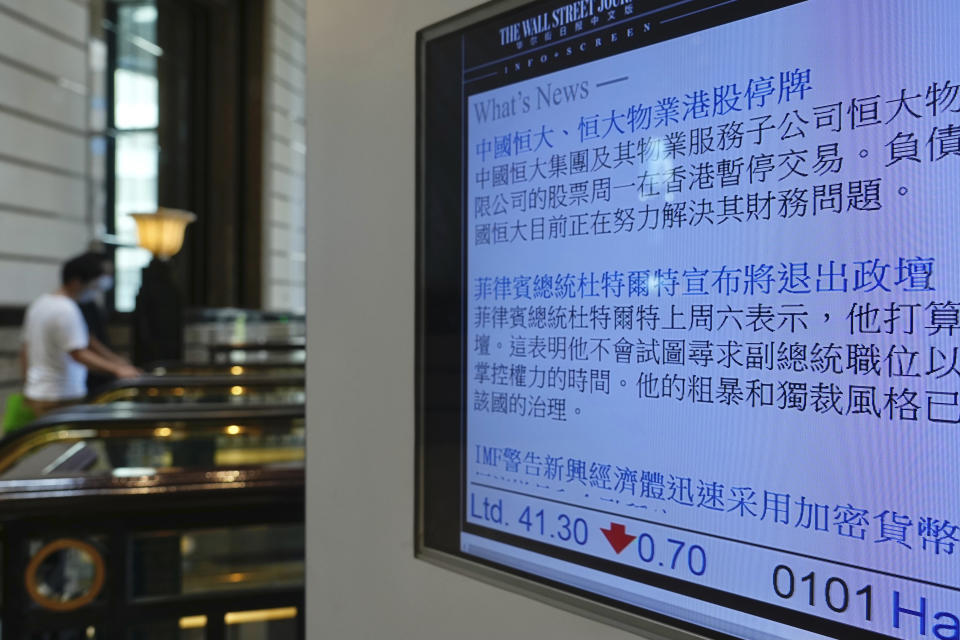 A screen displays news of real estate developer China Evergrande Group and its property management unit Evergrande Property Services were suspended from trading at a commercial building in Hong Kong Monday, Oct. 4, 2021. Shares in troubled real estate developer China Evergrande Group and its property management unit Evergrande Property Services were suspended from trading Monday in Hong Kong. (AP Photo/Vincent Yu)