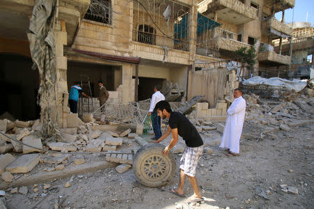 People inspect the damage at a site hit overnight by an air strike in the rebel-held area of Seif al-Dawla neighbourhood of Aleppo, Syria, September 30, 2016. REUTERS/Abdalrhman Ismail