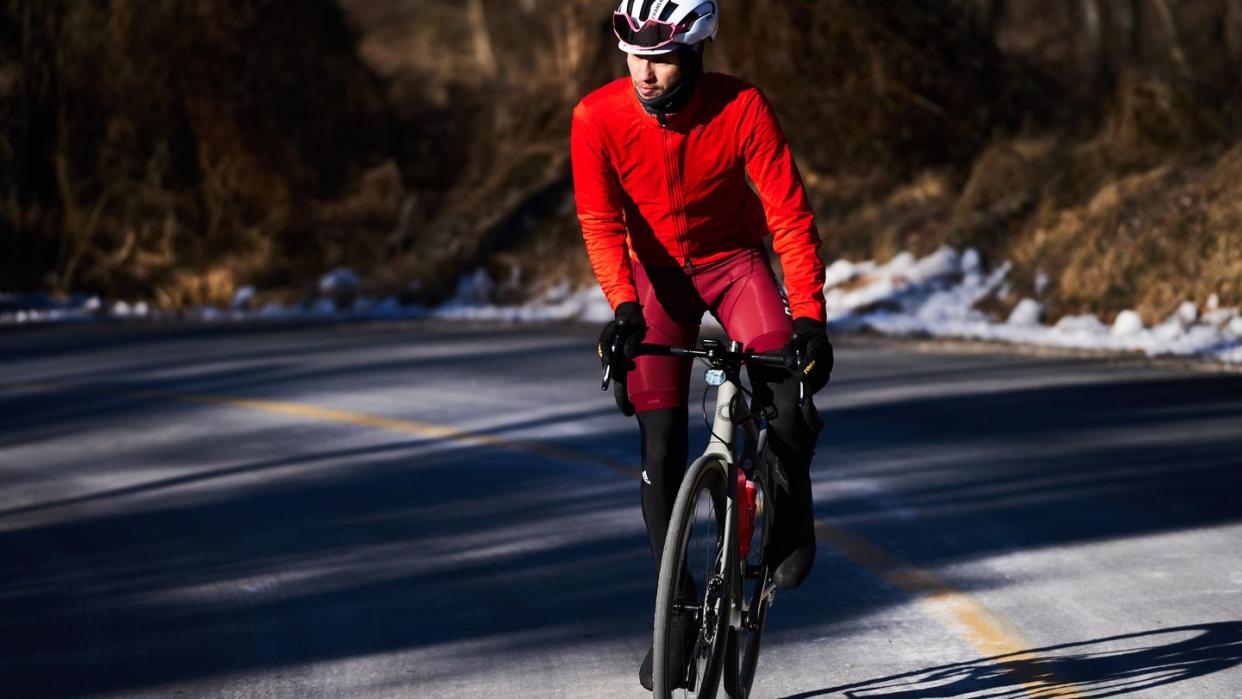 a man riding a bicycle on a road in winter