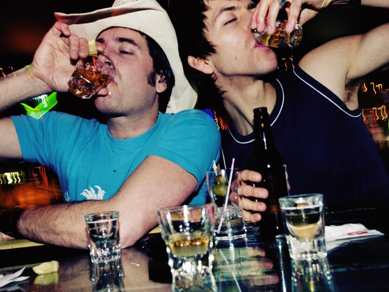 Two men drinking shots.